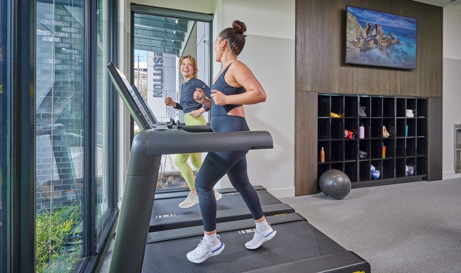 Two women running on treadmills Two women running on treadmills